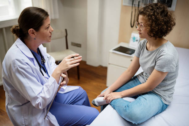 Doctor talking to teenager in surgery